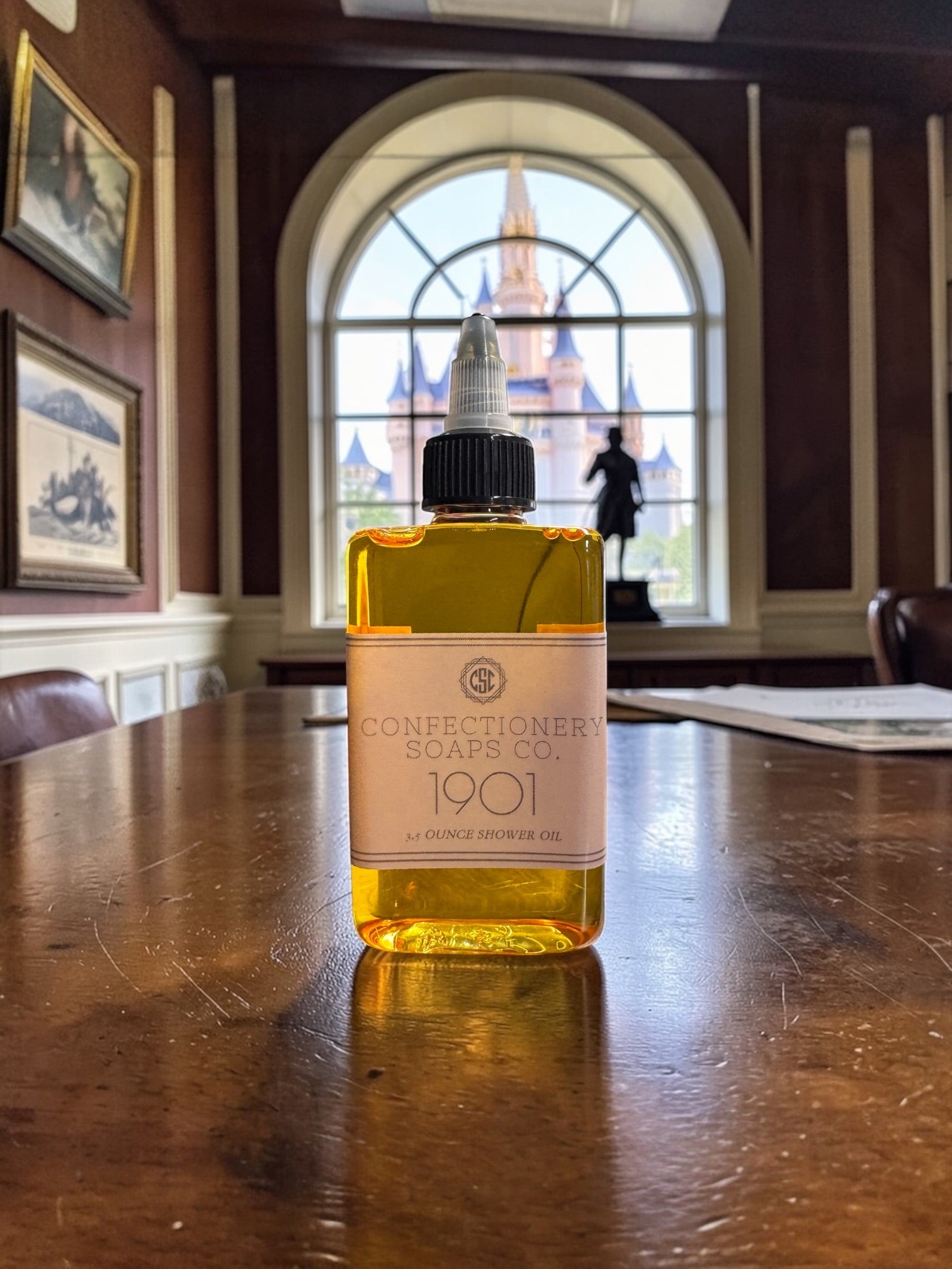 Bottle of Confectionery Soaps Co. 1901 on a wooden table with a castle in the background