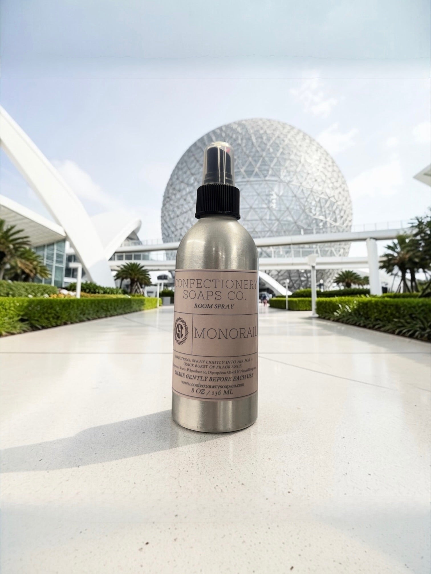 Bottle of Monarch room spray with a futuristic building in the background