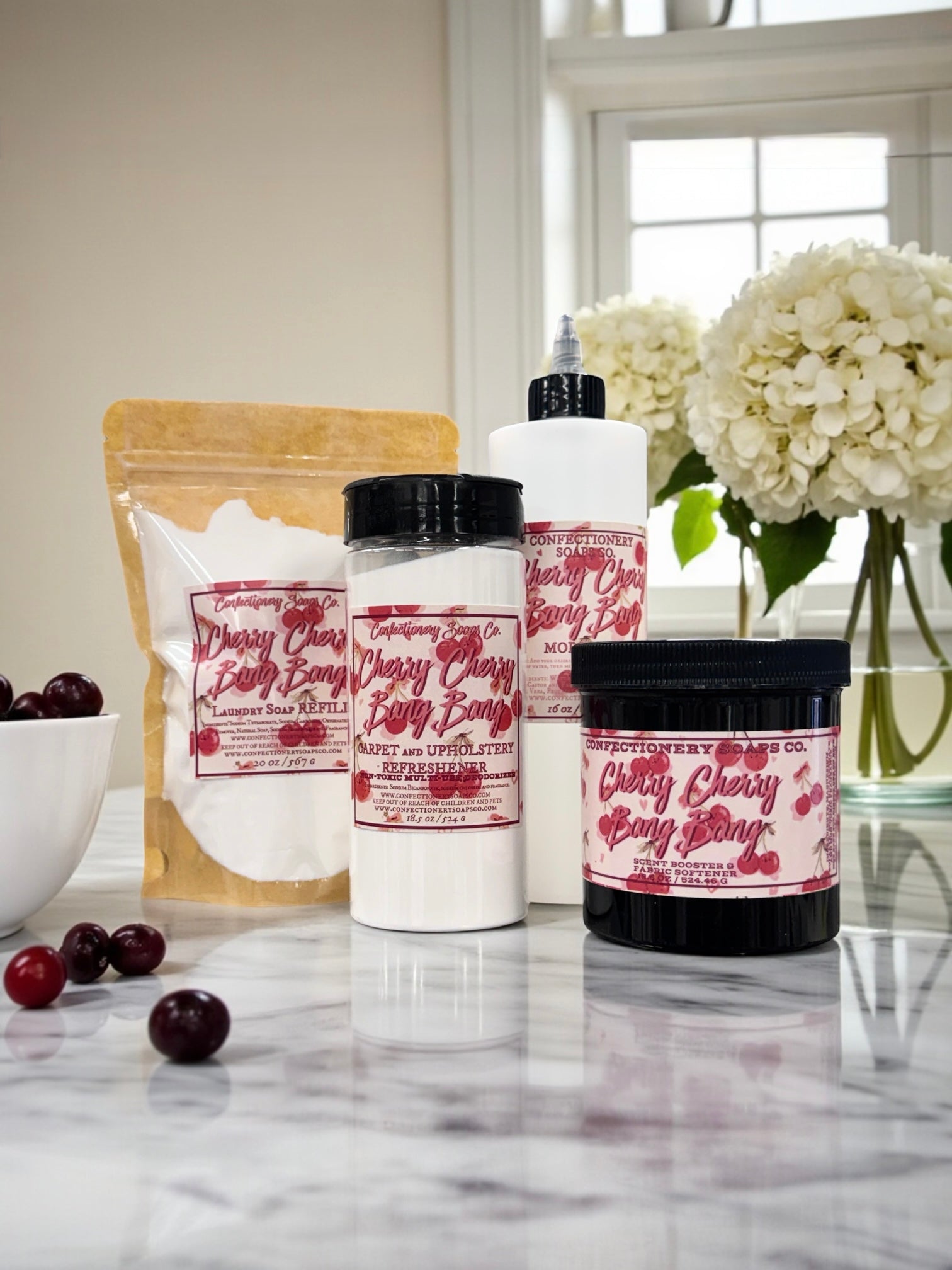 Cosmetic products with cherry-themed packaging on a marble surface.