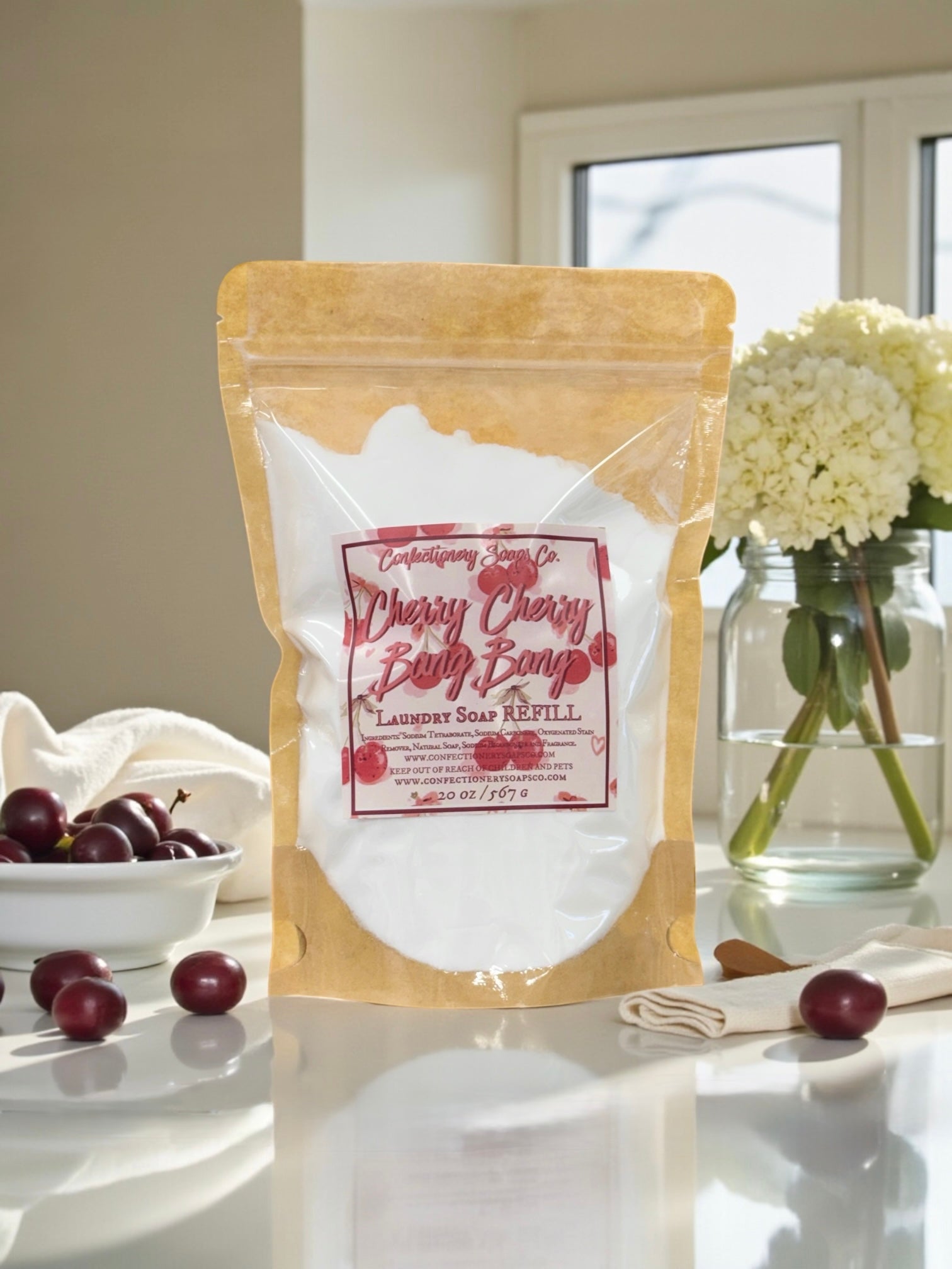 Laundry soap refill package with cherry design on a kitchen counter.